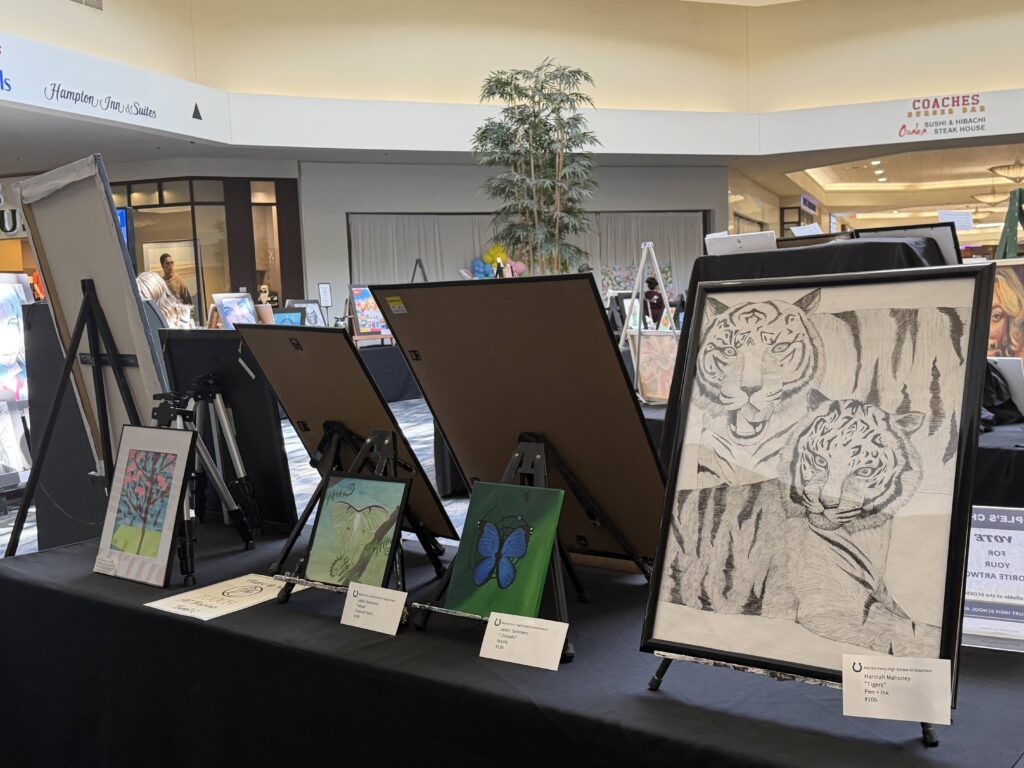 Rows of student artwork displayed on easels and black-draped tables inside the Ohio Valley Mall during the Belmont County Celebration of the Arts.