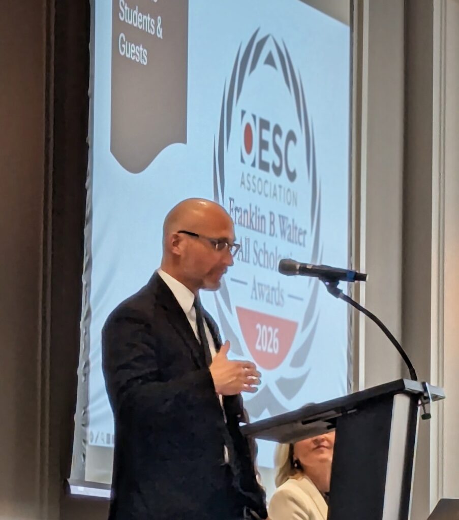 Craig Burford, Executive Director of OESCA, speaks at a podium during the 2026 Franklin B. Walter All-Scholastic Awards banquet.