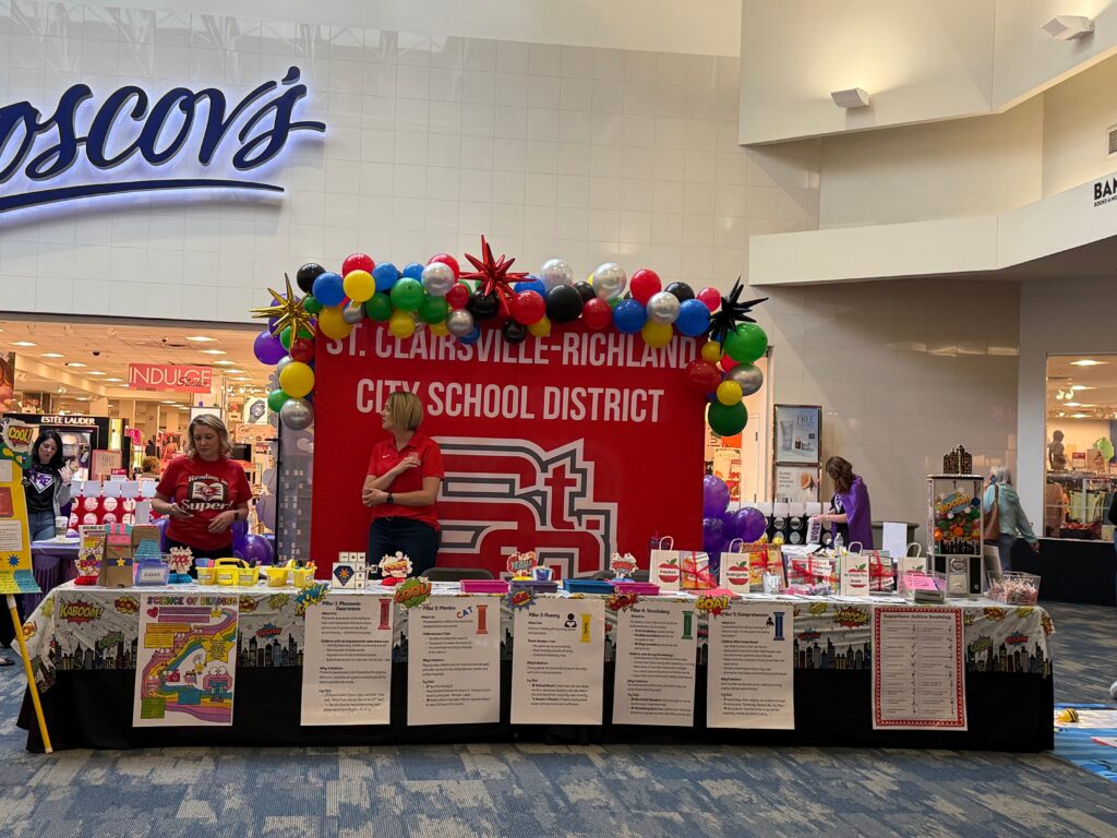 A decorated booth for St. Clairsville-Richland City School District with red and gold displays and activity stations.